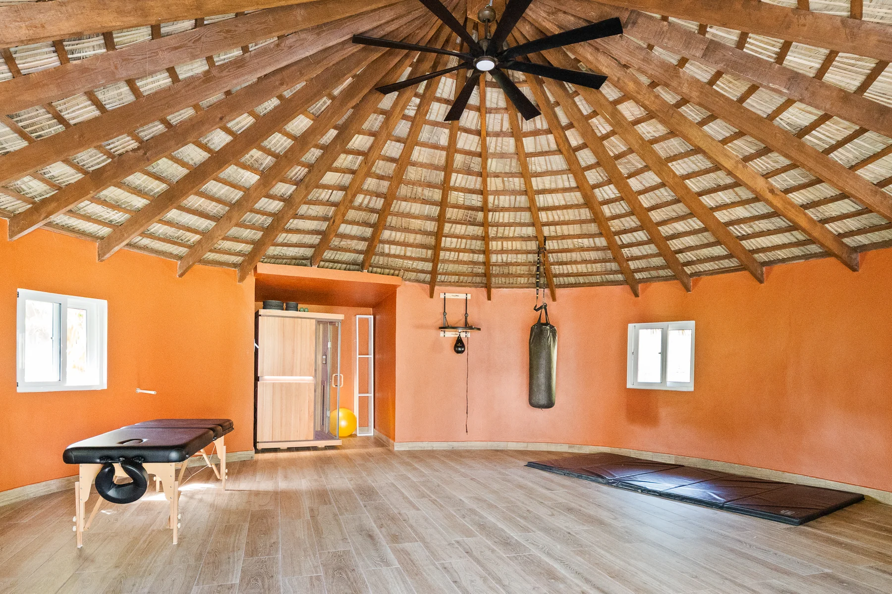 Thatched pavilion with open space and a ceiling fan