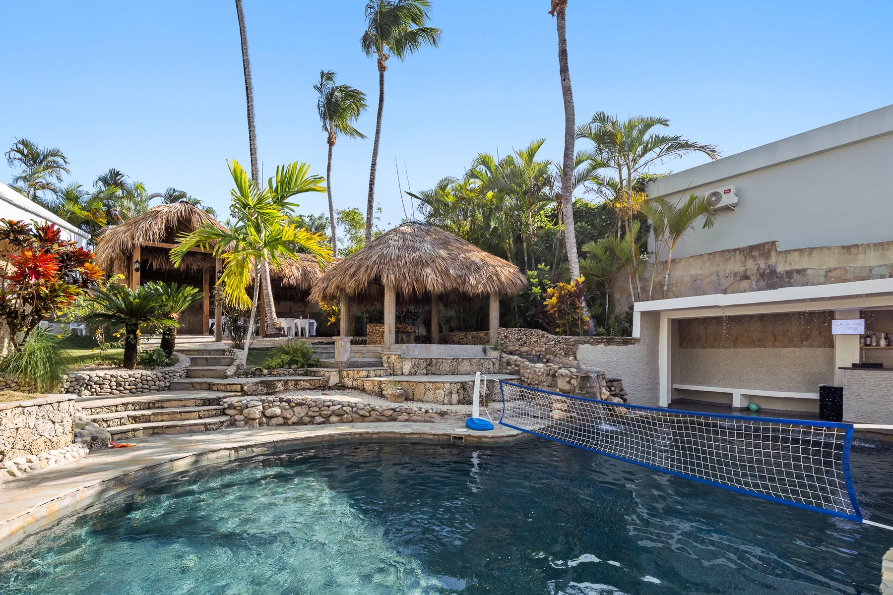 Laguna Oasis pool framed by palms and thatched shade