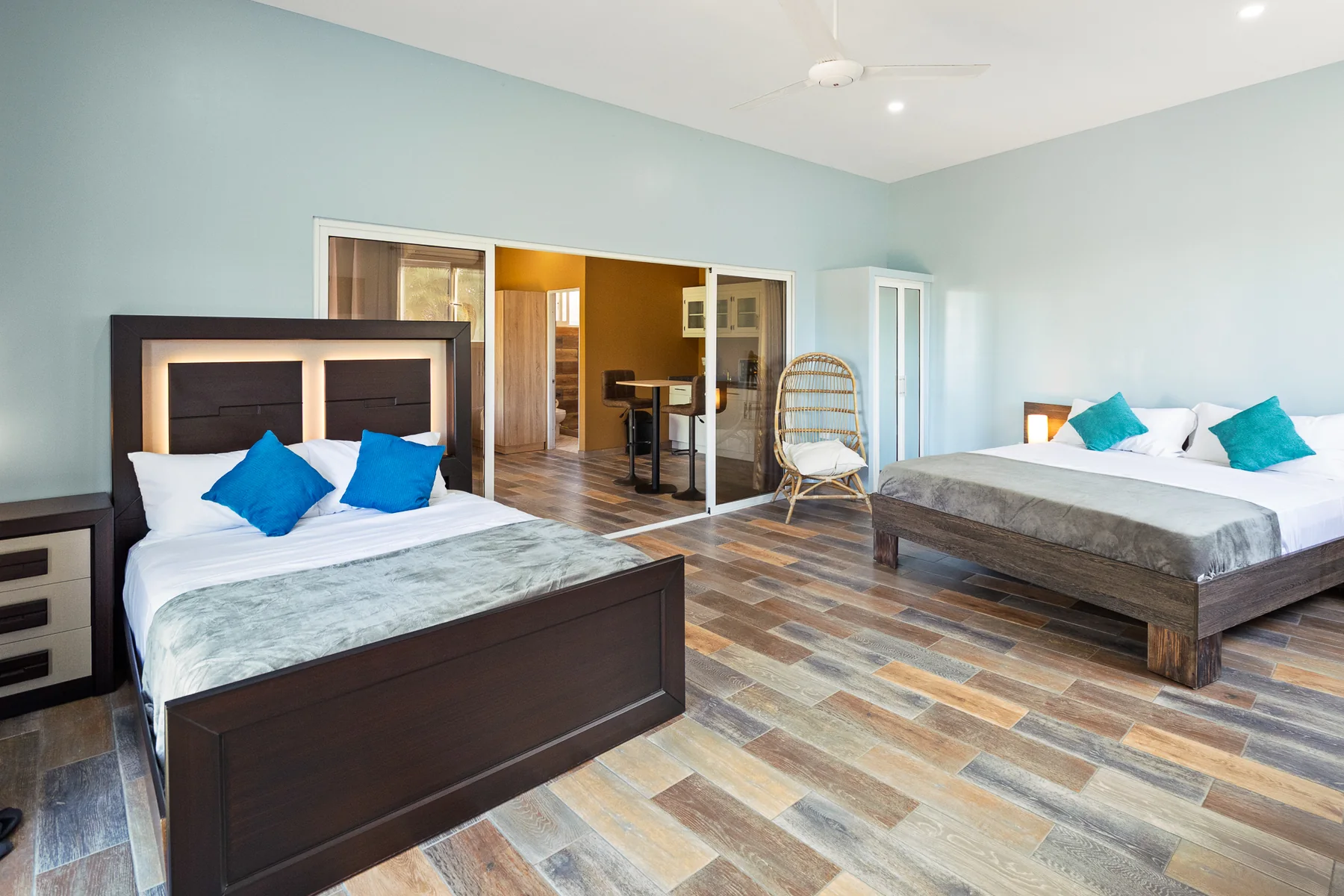 Bright double bedroom with natural wood and blue cushions